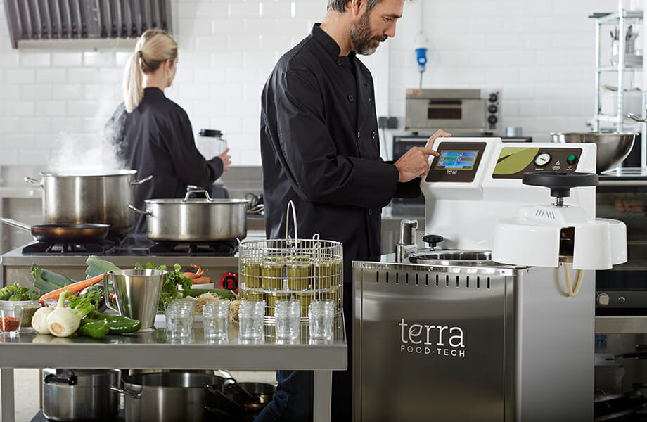 Cook preparing canned food at restaurant with a TERRA Food-Tech autoclave