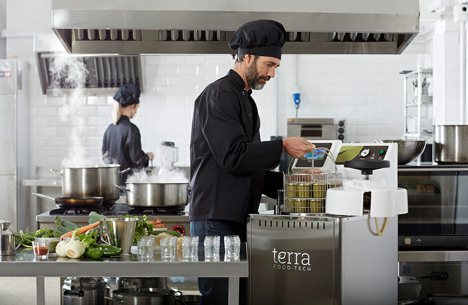 Cook preparing canned food at restaurant with a TERRA Food-Tech autoclave