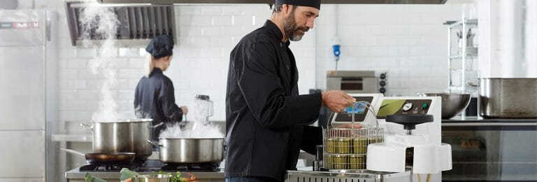 Cook preparing canned food at restaurant with a TERRA Food-Tech autoclave