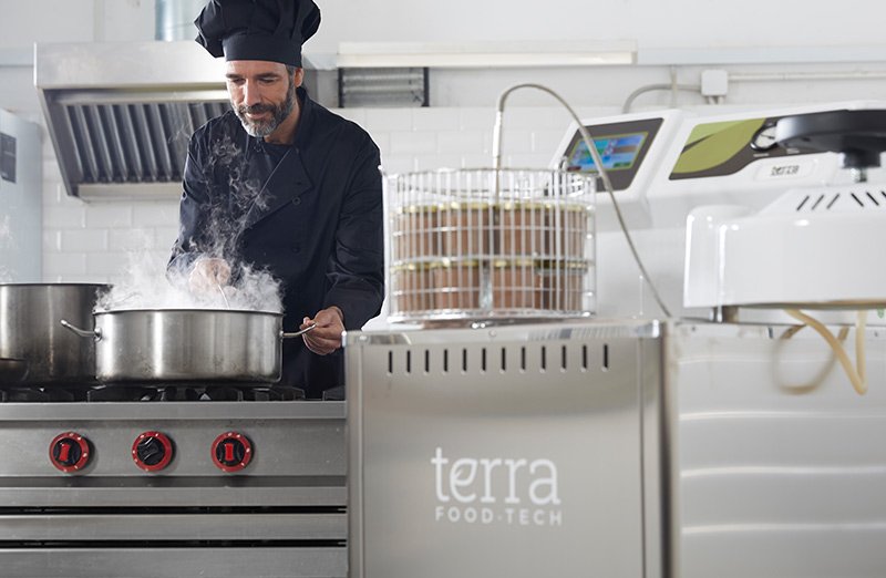 Cocinero cocinando pescado antes de la esterilización de pescado en conserva.