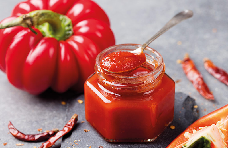 Tarro de verduras en conserva, compuesto por pimiento rojo, pimientos picantes y tomate.